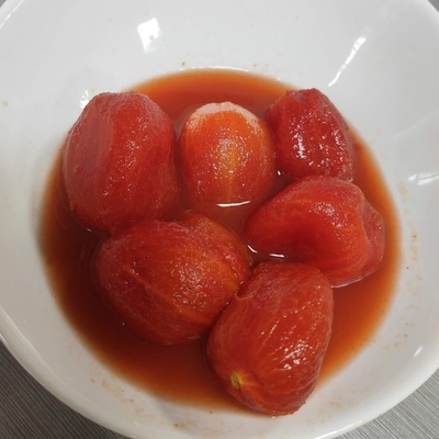 Heerlijke, zoete tomaten in blikken, geschild uit de versste grondstoffen